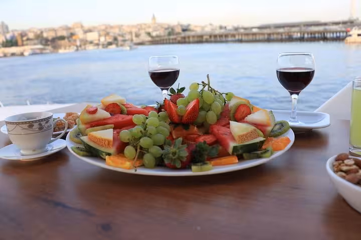 Fruit platter and red wine served on a luxury yacht deck during Istanbul Bosphorus sunset cruise