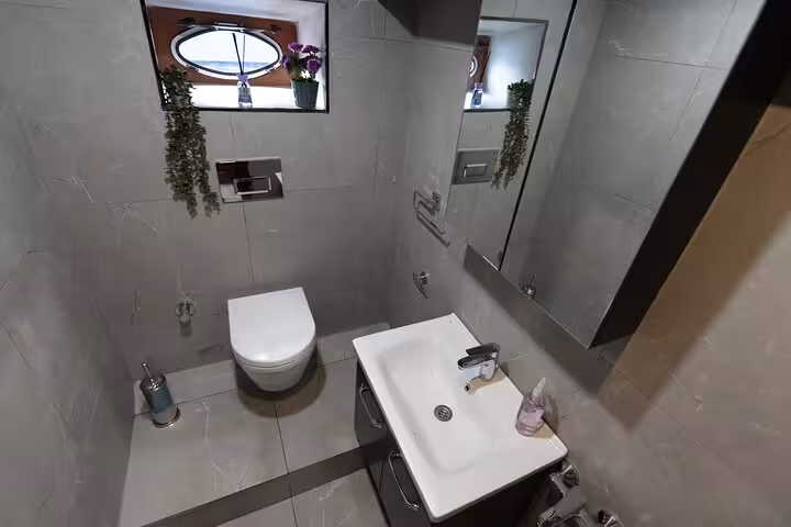 Stylish onboard restroom on private Istanbul Bosphorus yacht cruise, sink, mirror cabinet and porthole