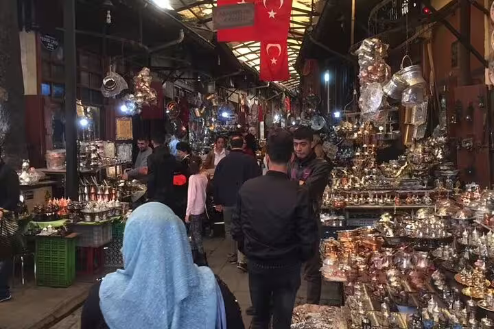 Bustling Istanbul Grand Bazaar aisle with Turkish flags, lanterns and souvenir stalls on a private Turkey tour