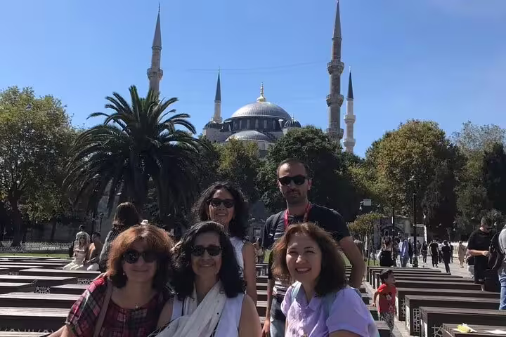 Group of tourists in front of the iconic Hagia Sophia under clear skies, showcasing Istanbul's vibrant culture.
