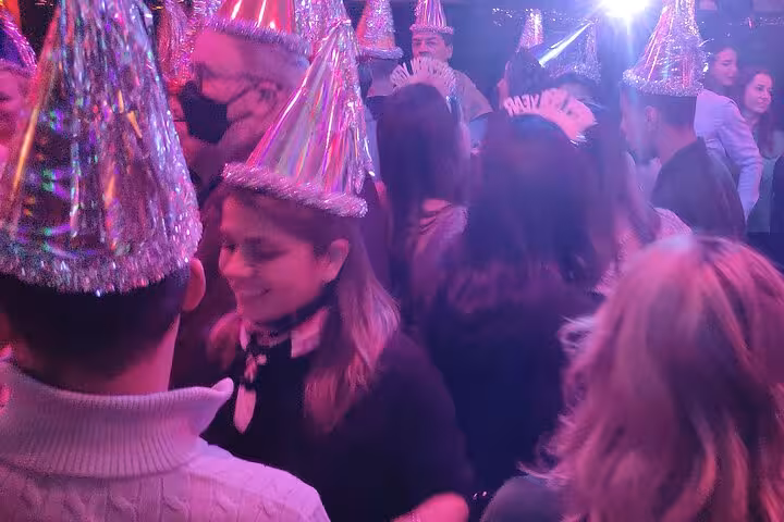 Guests dancing in glitter party hats on Istanbul New Year’s Eve party cruise, Bosphorus DJ and festive atmosphere