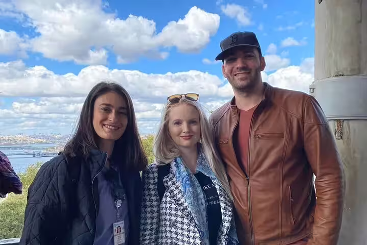 Happy tourists enjoying a private tour from Galataport with a stunning Istanbul skyline in the background.