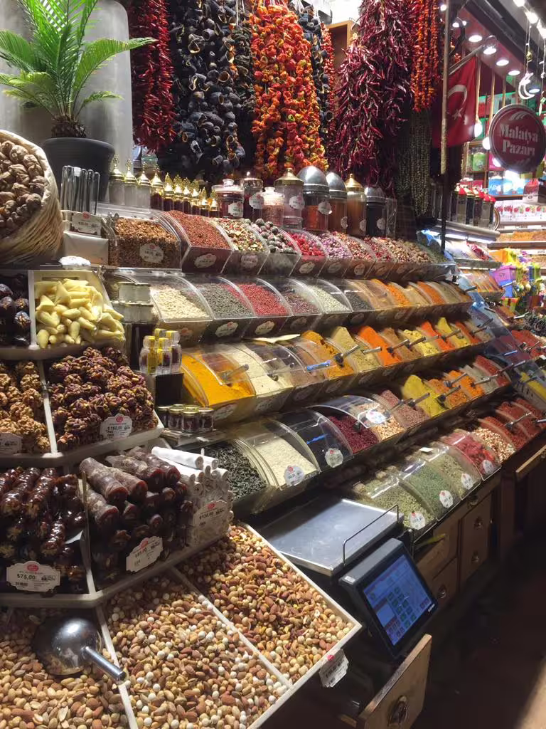 Colorful spice and nut stall at Istanbul Spice Bazaar on a private guided day tour, featuring Turkish delights