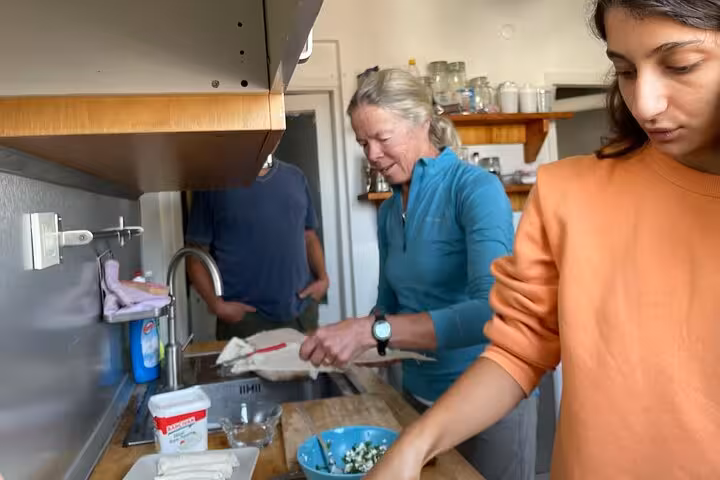 Guests cooking healthy Turkish breakfast together in Istanbul home kitchen, hands-on after yoga morning tour