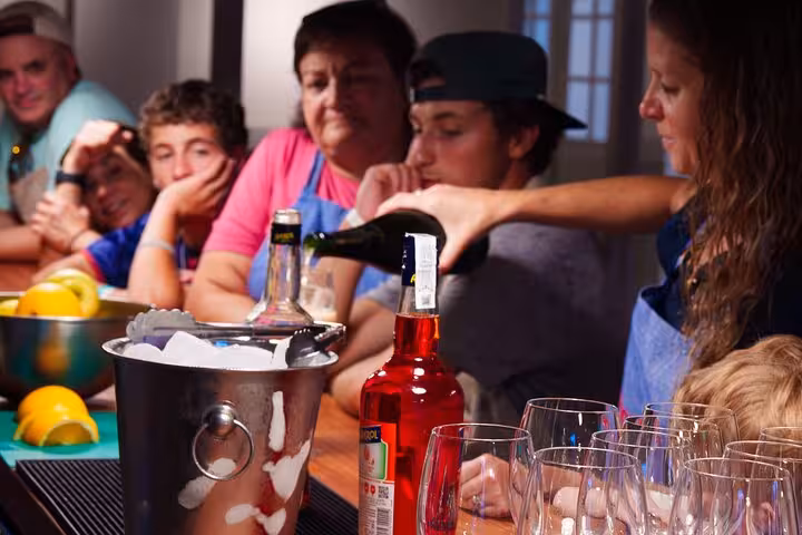 Group enjoying an Italian aperitivo session in Barcelona, watching a demonstration of drink preparation at the bar.