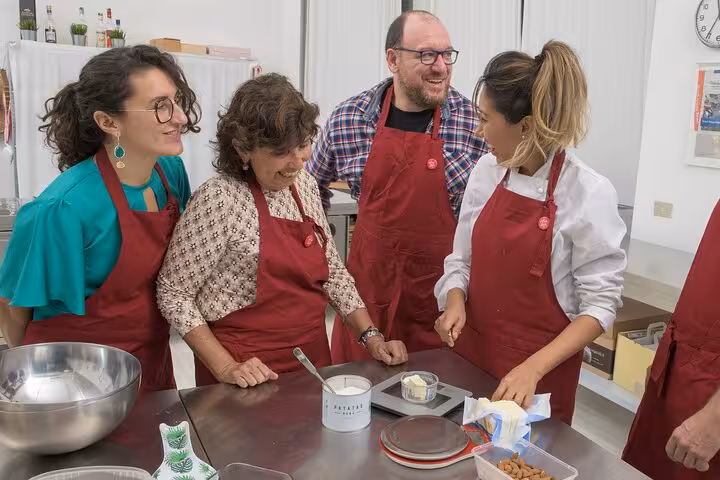 Group enjoying an Italian cooking class, learning traditional recipes from a skilled Italian chef in a cheerful setting.
