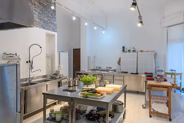 Spacious Italian cooking studio featuring stainless steel workstations and fresh ingredients for classes.