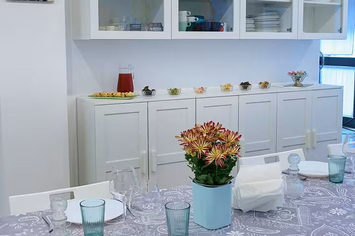 Charming Italian kitchen setup with a beautifully set dining table ready for a cooking class experience.