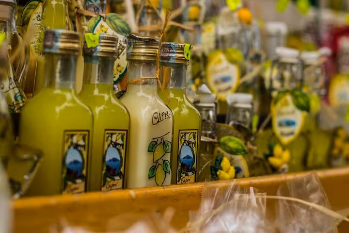 Assorted bottles of Italian limoncello in Sorrento market, a must-try local specialty on the Naples to Pompeii tour.