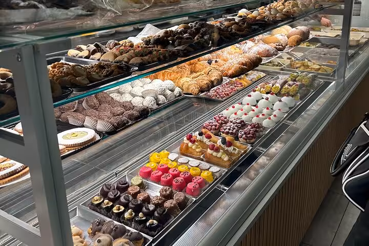 Display of assorted Italian pastries and desserts in a Catania bakery, offering a sweet culinary experience.