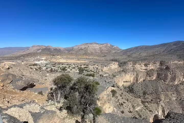 Panoramic landscape of Jabal Al Akhdar showcasing mountainous terrain and scattered greenery in Oman.