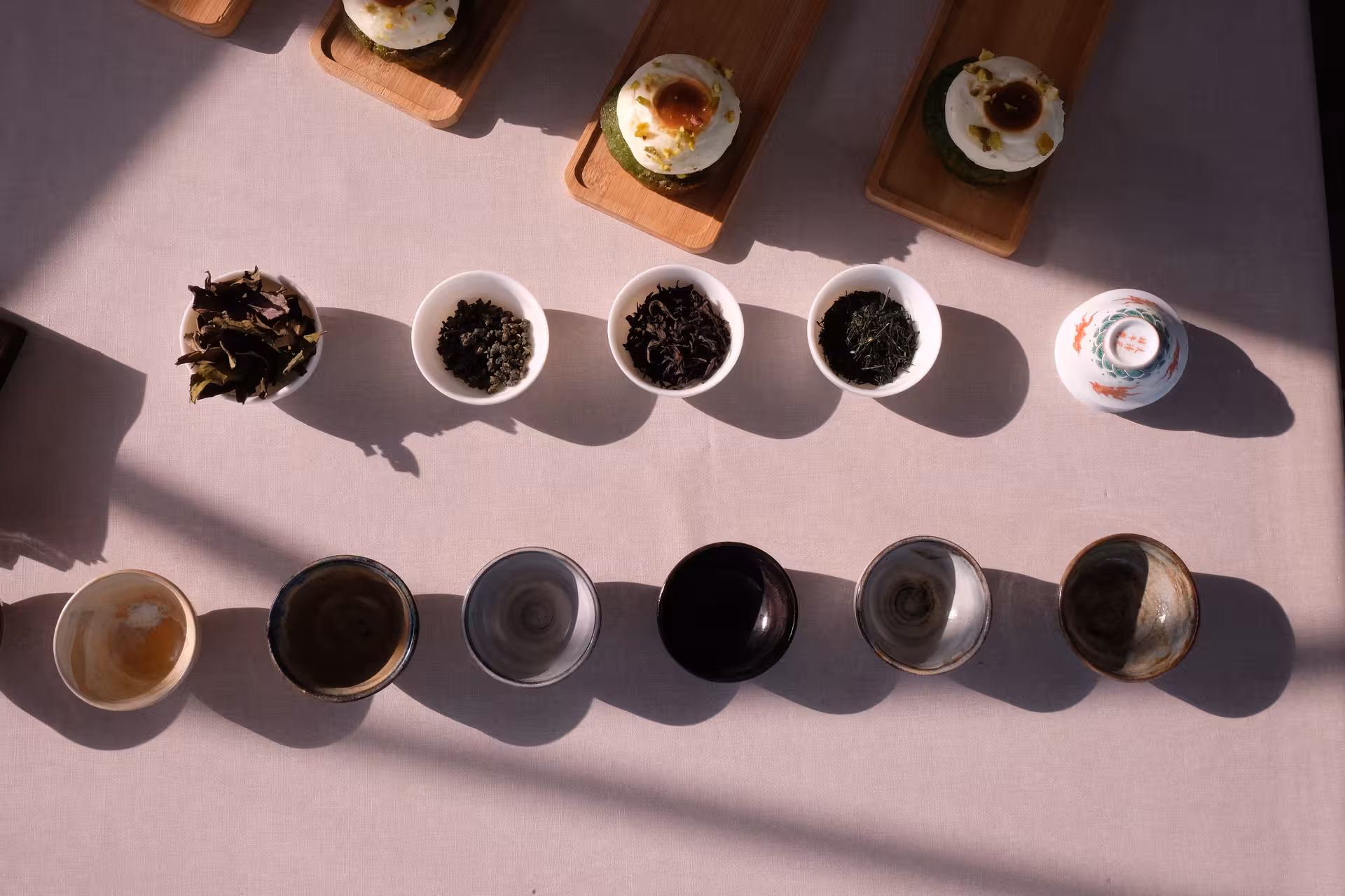 Loose leaf tea bowls and ceramic cups arranged for a Japanese tea ceremony tasting with matcha sweets