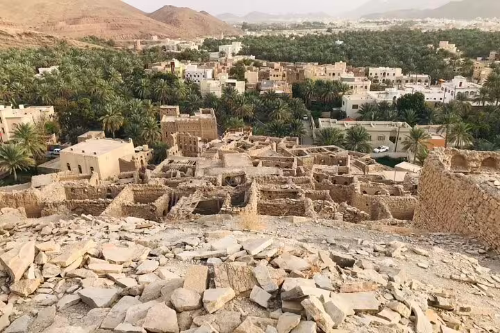 Panoramic view of ancient stone structures and lush greenery in Jebel Akhdar Al Suwjara Village, Oman.
