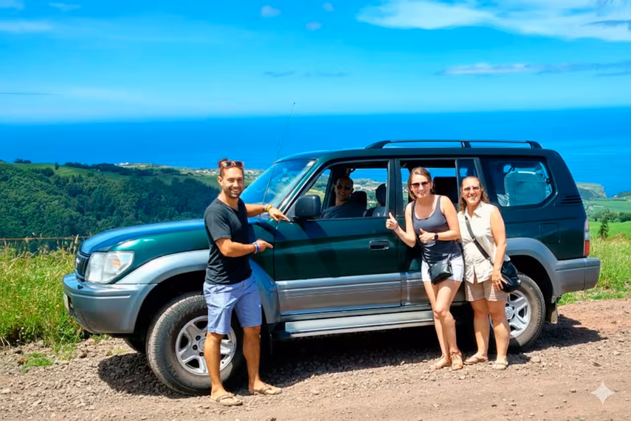 Smiling friends posing by a 4x4 jeep on a hilltop viewpoint during a full-day coast to coast off-road tour with ocean views