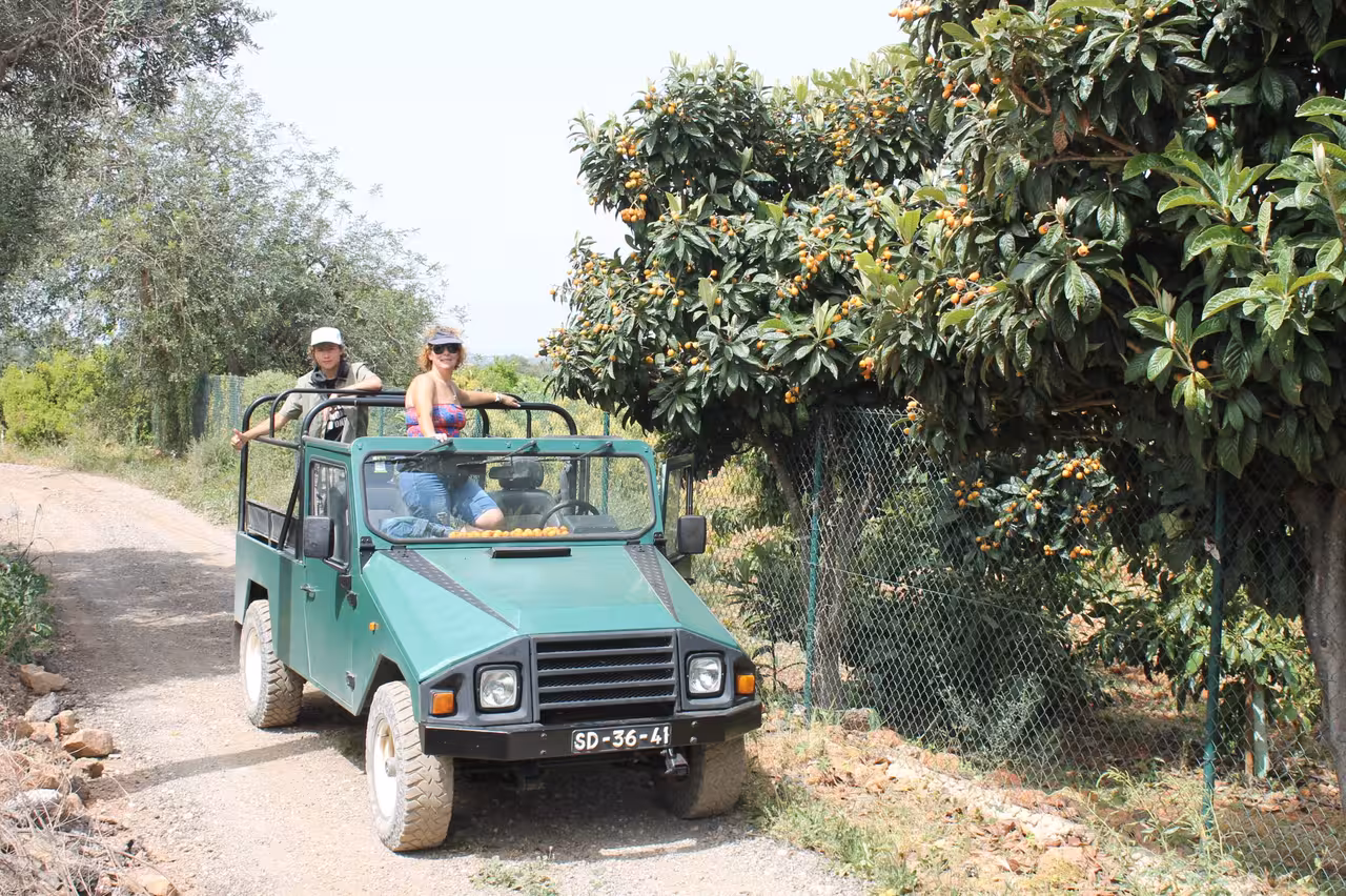 Open-top jeep safari driving past Algarve orchards on the Benagil cliffs coast tour, off-road countryside adventure