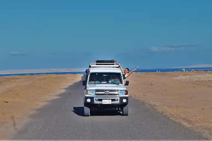4x4 Jeep safari from Hurghada driving through desert road toward the Red Sea, stargazing tour adventure