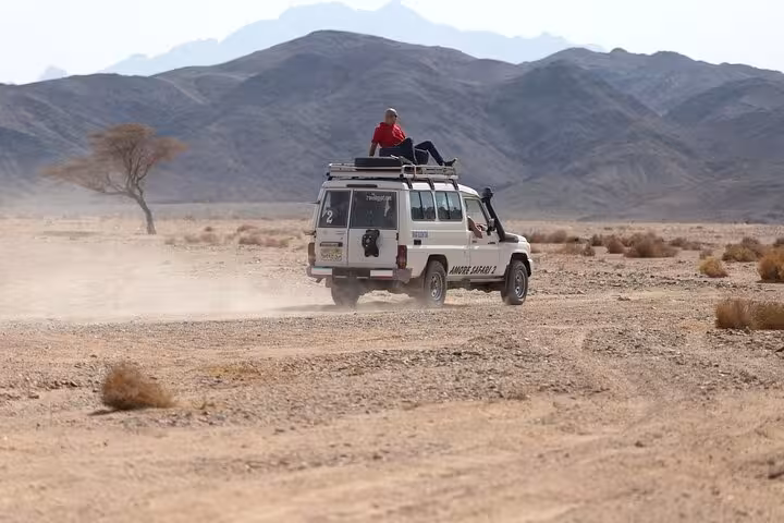 4x4 Jeep safari crossing Hurghada desert plains, heading to Bedouin camp dinner and night stargazing tour