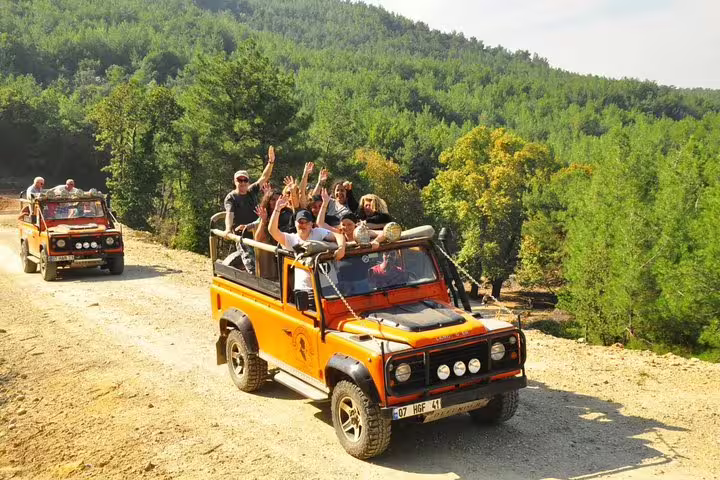 Group enjoying a thrilling jeep safari adventure through lush landscapes from Kusadasi, capturing the excitement.