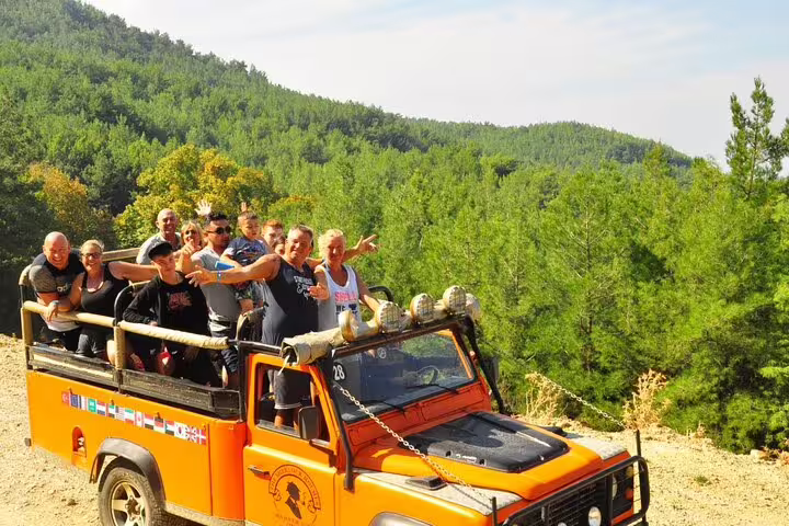 Group enjoying an adventurous Jeep Safari through lush forests near Kusadasi National Park.