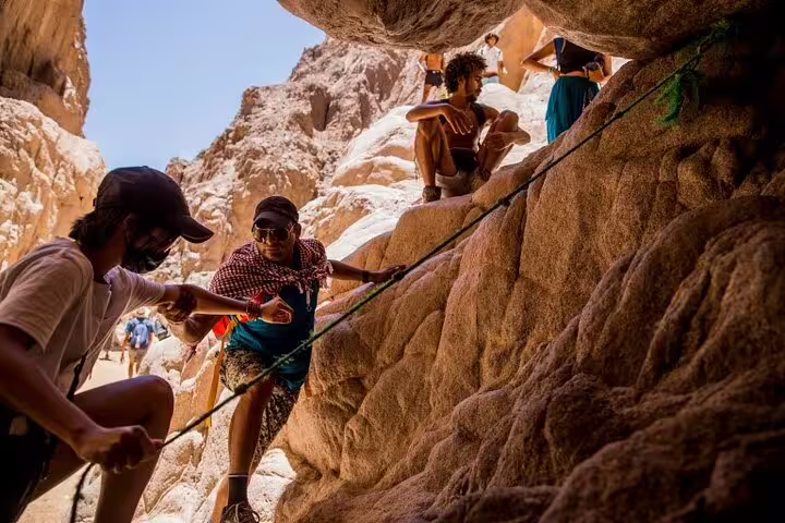 Travelers at Lost Lake lagoon in Sinai rocks, private Jeep safari tour from Sharm El Sheikh with Dahab visit