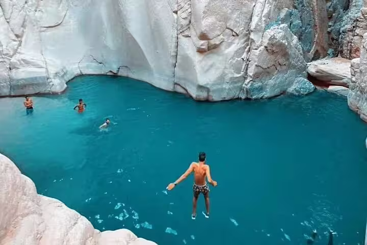 Guests swimming and cliff jumping at Lost Lake lagoon on private Jeep safari from Sharm El Sheikh to Dahab