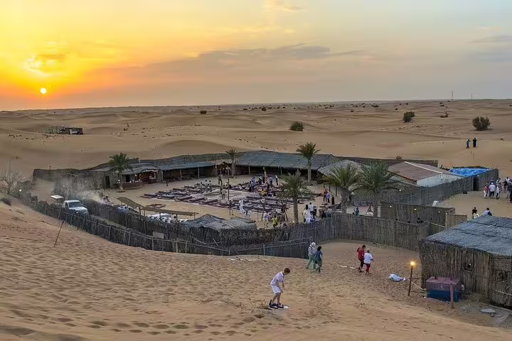 Sunset over Marsa Alam desert camp on jeep safari adventure, with Bedouin dinner setup and sand dunes