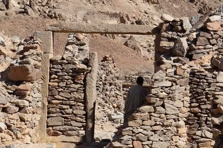 Traveler explores stone doorway ruins at Mons Claudianus on a Safaga desert Jeep safari tour in Egypt