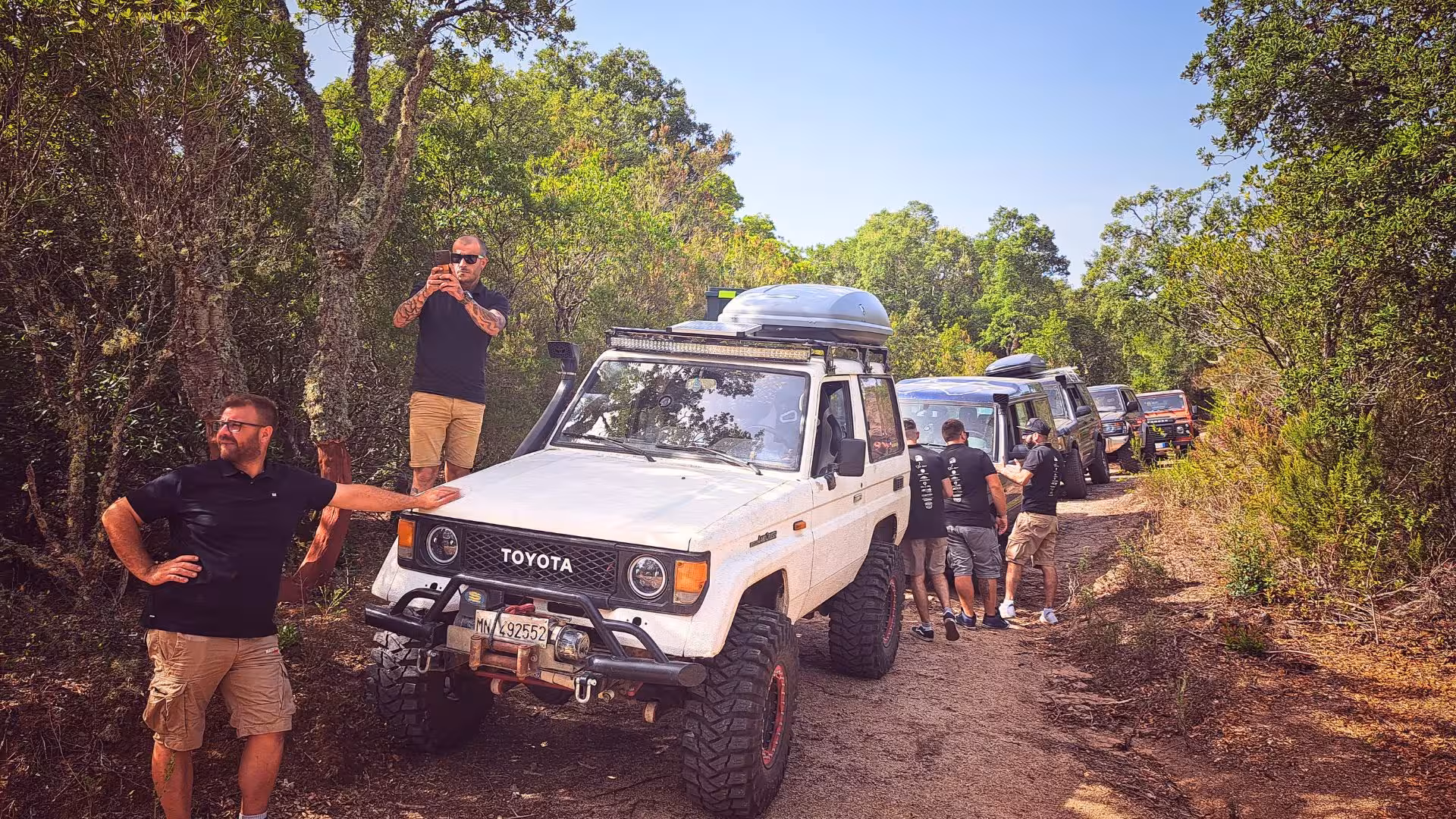 Group of tourists enjoying an off-road jeep tour through the lush forests of Mount Limbara from Tempio.
