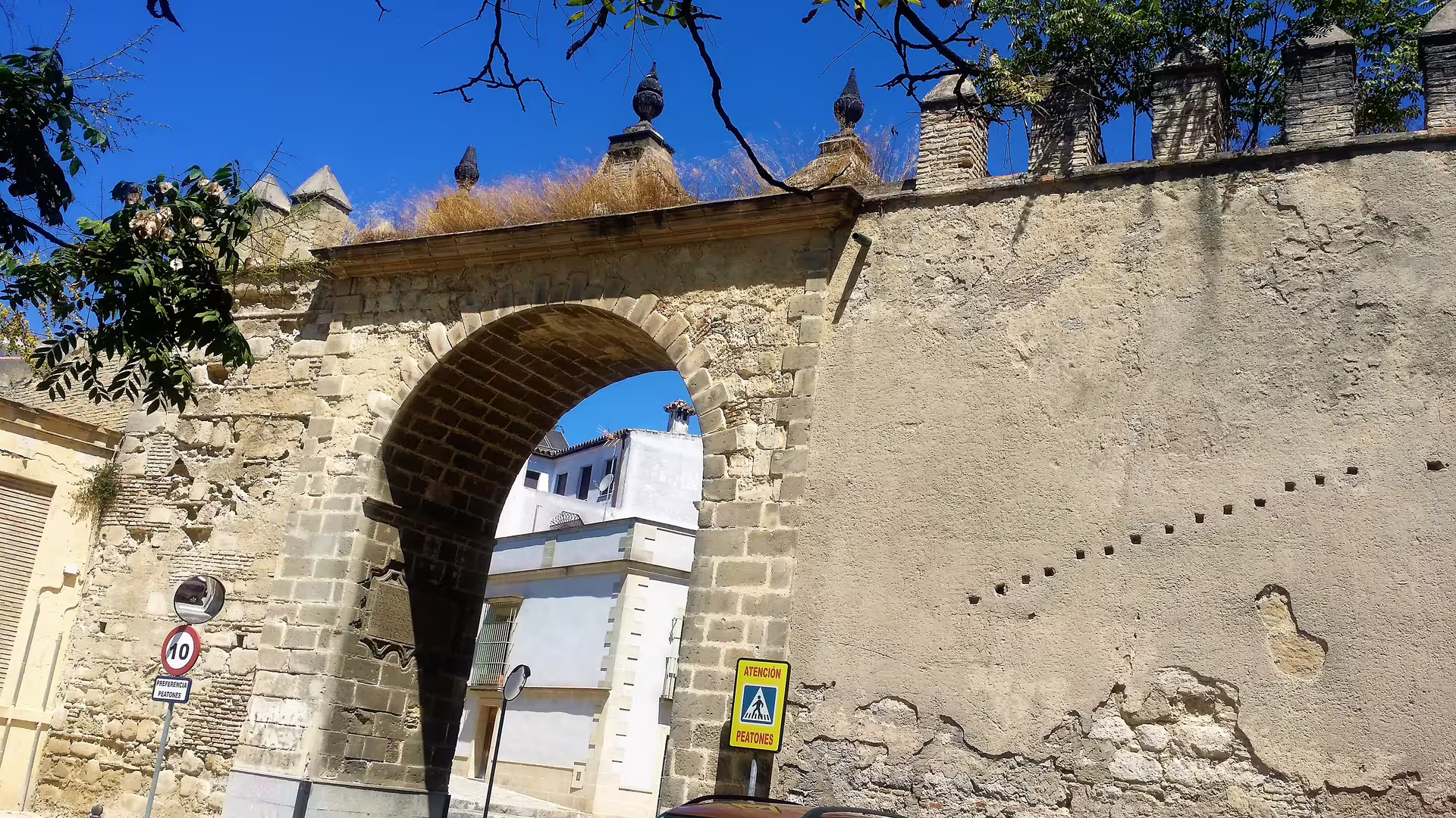 Historic stone arch gate in Jerez old town, stop on private day trip from western Costa del Sol with hotel pick-up