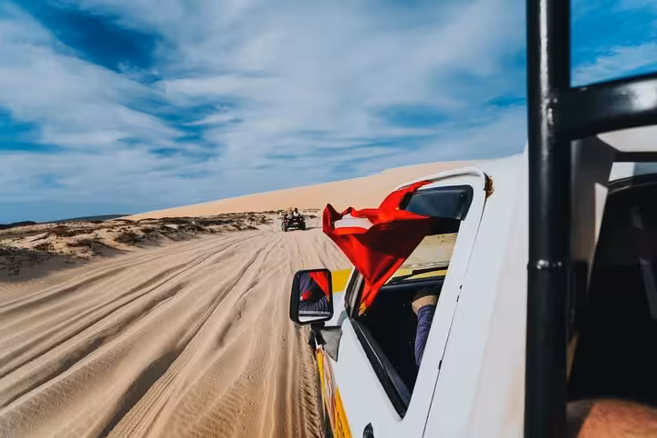 4x4 vehicle driving through Jericoacoara sand dunes on a guided reliable airport transfer tour