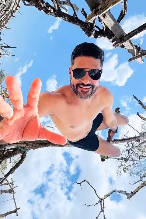 Smiling traveler on a tree swing with ocean breeze, a fun stop on the Jericoacoara West Coastal Tour