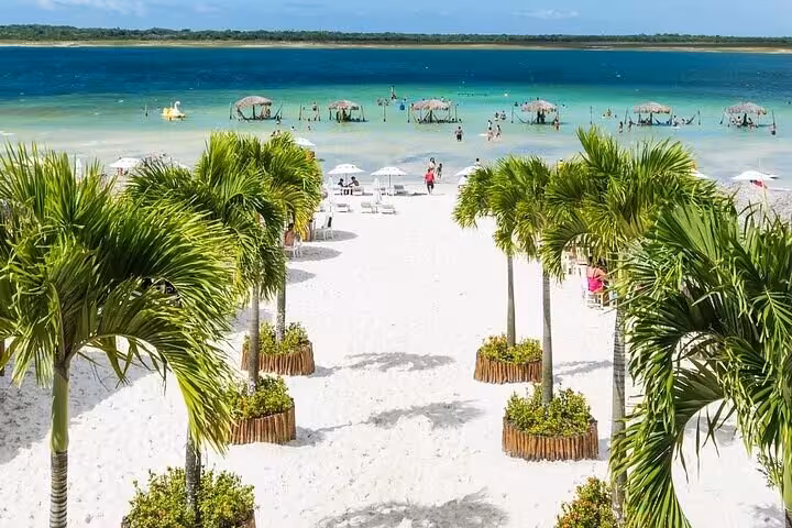 Palm-lined white sand at Lagoa do Paraíso with hammocks in water, highlight of Jericoacoara East Coast tour