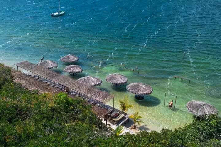 Overwater hammocks and thatched umbrellas at Lagoa do Paraíso on Jericoacoara East Coast tour