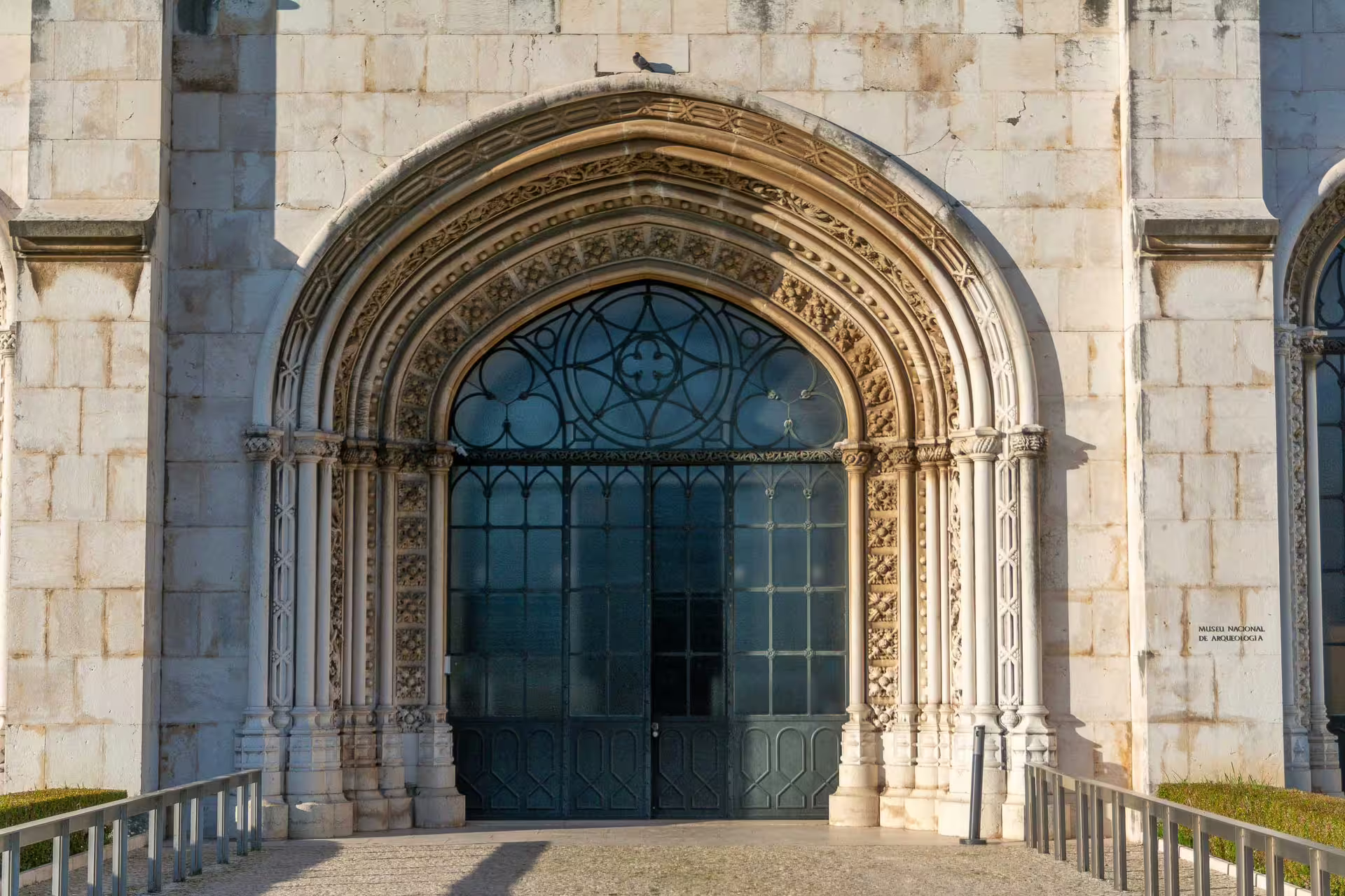 Ornate stone archway of Jerónimos Monastery in Belém, Lisbon, capturing intricate Gothic architecture during a sunset photography walk.