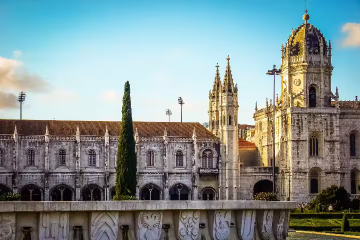 Majestic Jerónimos Monastery basking in golden sunset light during a Belém Photography Walk in Lisbon, Portugal.