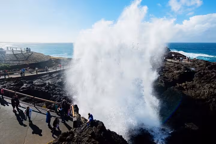 Tourists watch a spectacular water spray at the famous blowhole in Jervis Bay, perfect for a private tour experience.