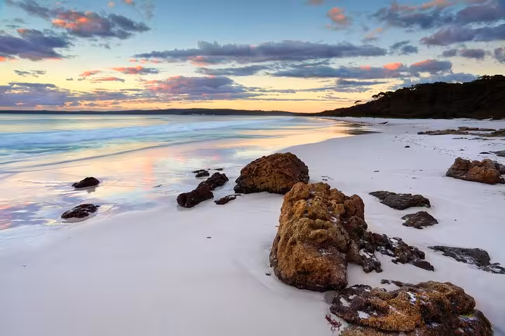 Breathtaking sunset over the serene shores of Jervis Bay, featuring stunning rock formations and calm waters.
