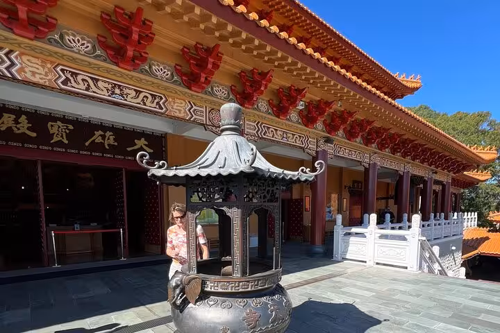 Visitor explores Nan Tien Temple's ornate architecture during Jervis Bay private tour with convenient pickup and drop-off.