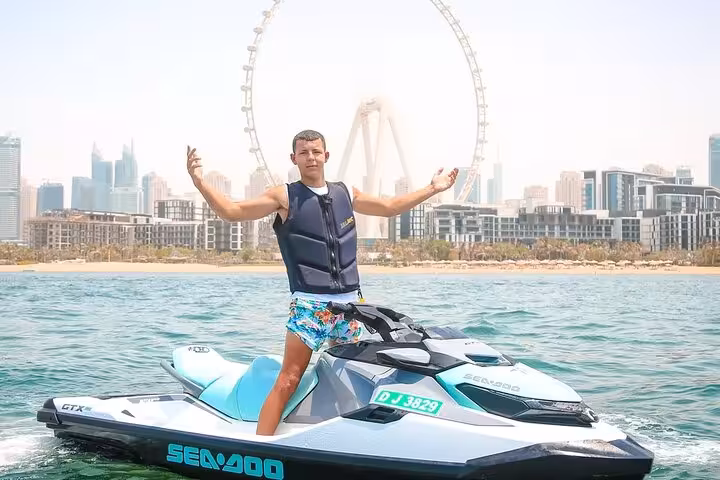 Man posing on a Sea-Doo jet ski in Dubai with Ain Dubai behind, perfect for 30-minute or 1-hour ride