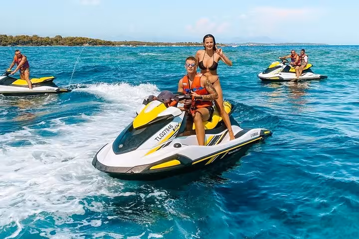 Couple riding a Yamaha jet ski on turquoise waters in Golfe-Juan with other riders in background