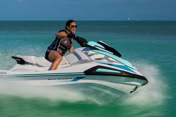Rider speeding a jet ski on turquoise sea from San Antonio Ibiza to Atlantis, guided coastal adventure