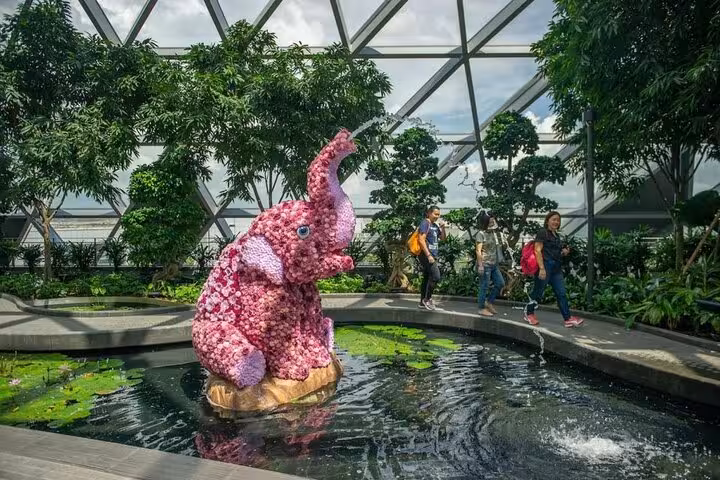 Pink flower elephant sculpture by pond on Jewel Changi Airport Walking Net route with Canopy Park entry