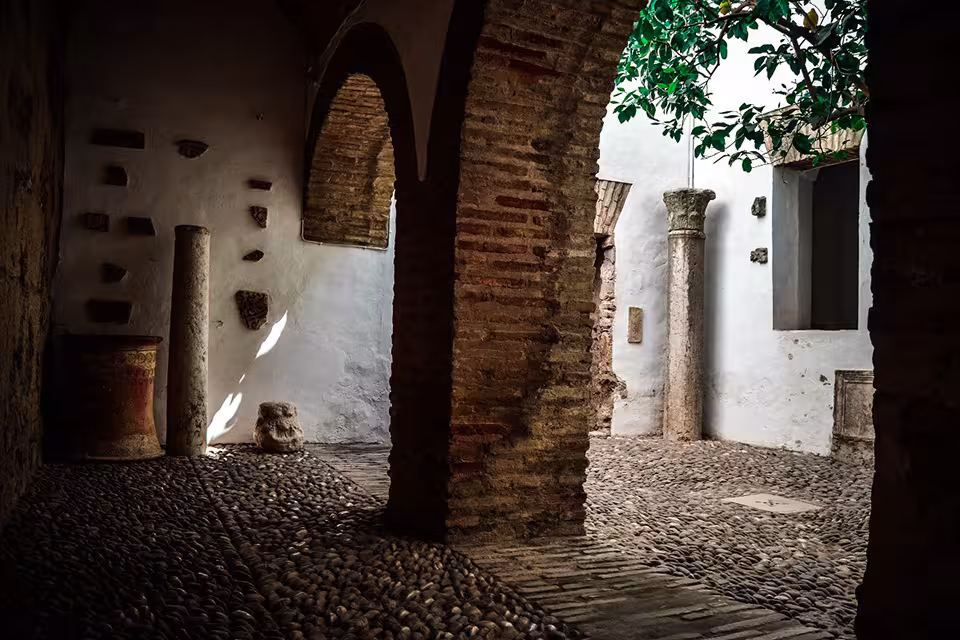 Stone courtyard with arches and columns in the Jewish Quarter, featured in synagogue tour experience.
