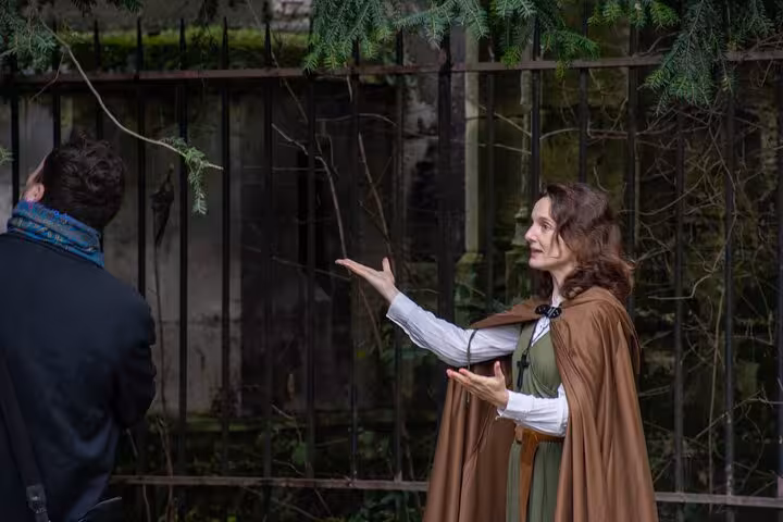 Medieval costumed guide in brown cloak gesturing during Joan of Arc walking tour in Rouen