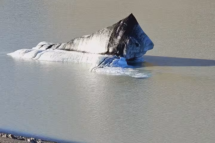 Dark-tipped iceberg floating in the glacial lagoon at Jokulsarlon, Iceland