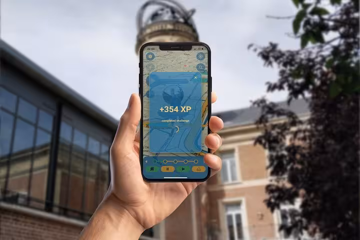 Hand holding smartphone displaying +354 XP completed challenge on Jules Verne walking tour app in Amiens