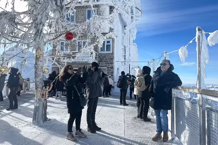 Visitors explore the frosty observatory deck at Jungfraujoch, capturing breathtaking views of the Swiss Alps.