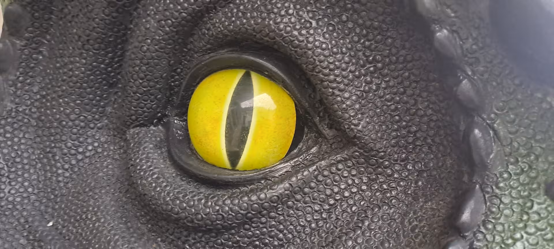 Close-up of a lifelike dinosaur eye model at the Jurassic Museum of Asturias, emphasizing its realistic details.