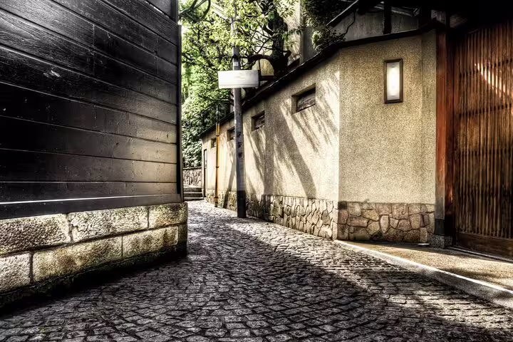 Narrow cobblestone alley in Kagurazaka Tokyo flanked by traditional stone walls and wooden buildings