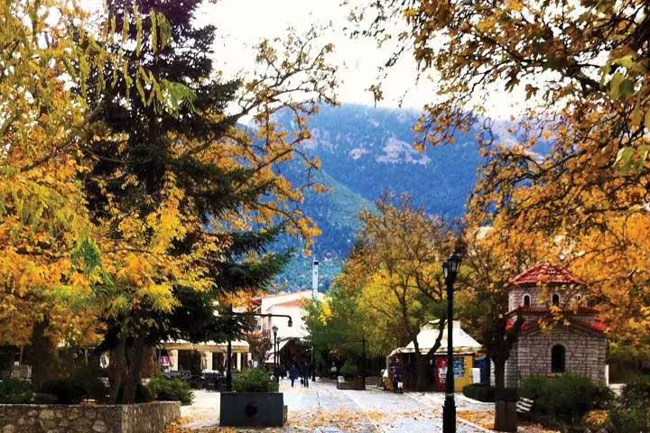 Kalavryta village square in autumn with mountain views, a scenic stop on the Cave of Lakes day tour